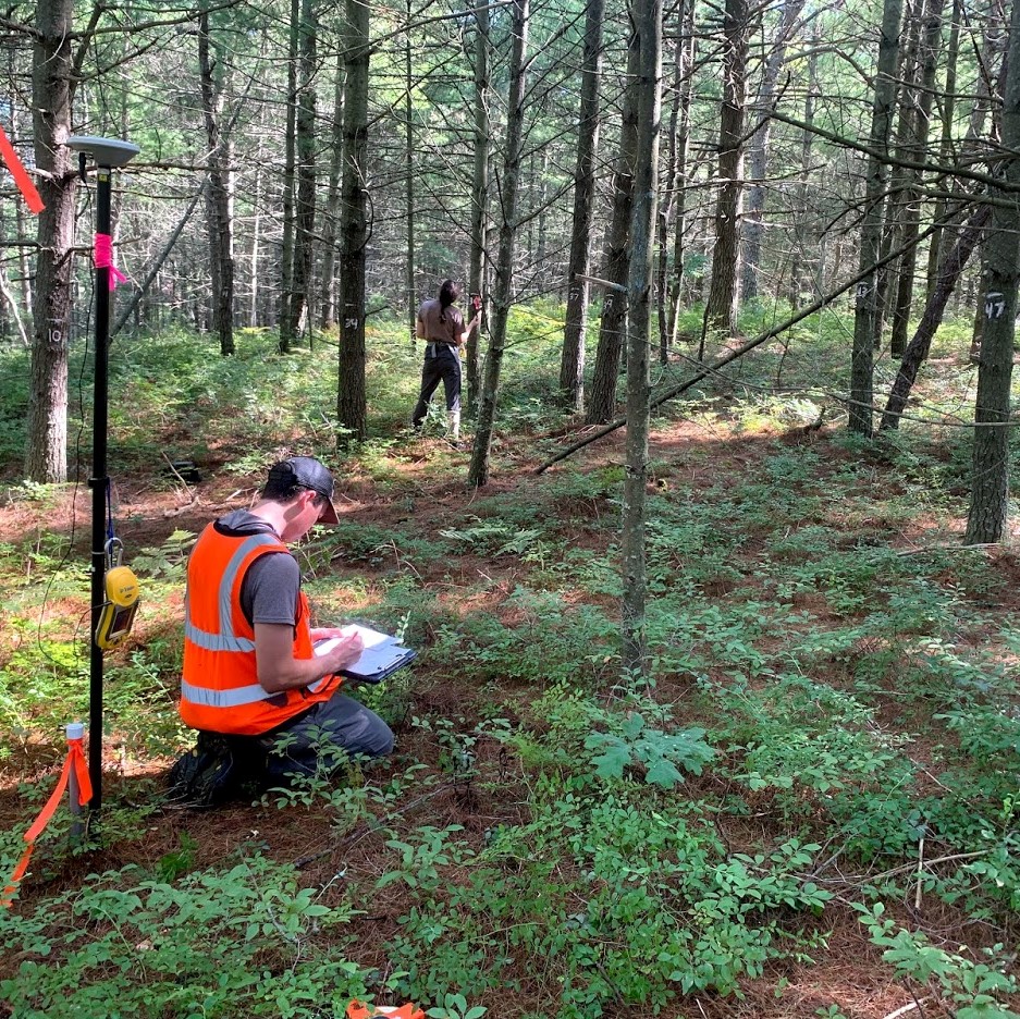 image of research tech in orange vest writing on a clipboard